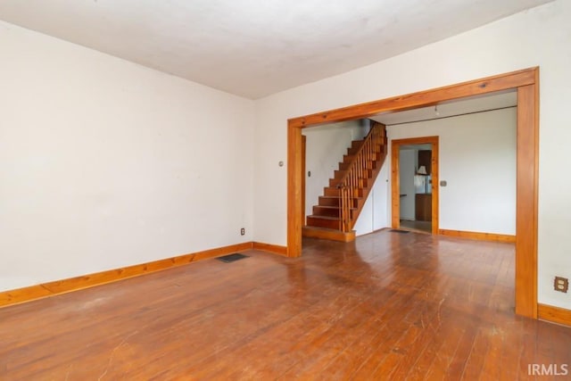 2645 S Greensboro Pike, New Castle, IN 47362 - spare room with baseboards, visible vents, stairway, and hardwood / wood-style floors