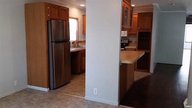 905 Stewart Ave, Evansville, IN 47715 - kitchen with freestanding refrigerator, light countertops, baseboards, glass insert cabinets, and crown molding