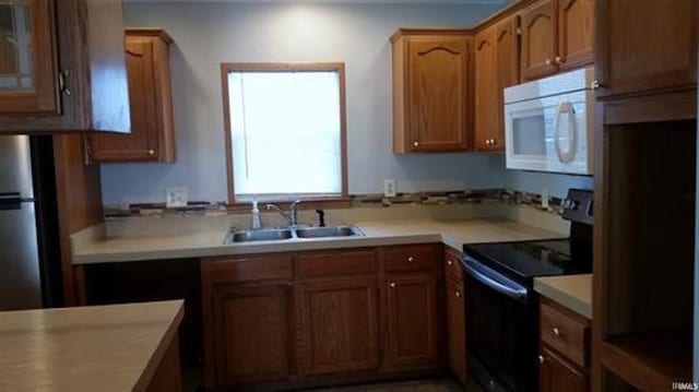 905 Stewart Ave, Evansville, IN 47715 - kitchen with black appliances, a sink, light countertops, brown cabinets, and glass insert cabinets