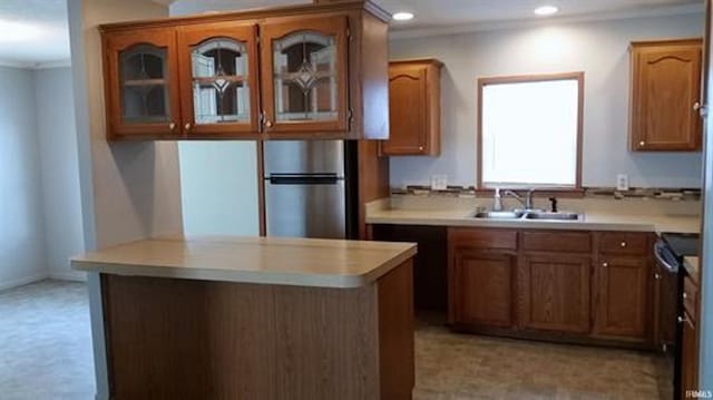 905 Stewart Ave, Evansville, IN 47715 - kitchen with freestanding refrigerator, a sink, light countertops, brown cabinetry, and recessed lighting