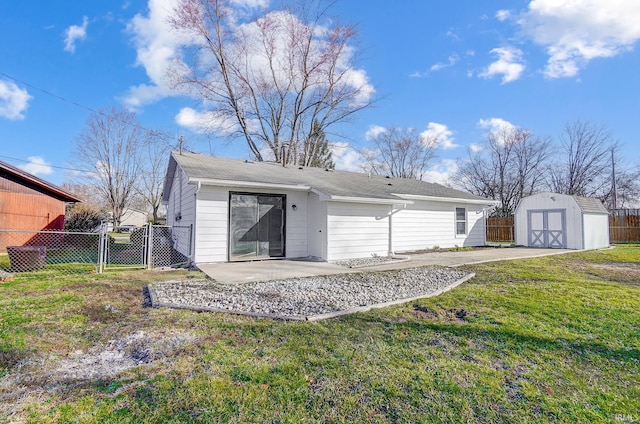 rear view of property with a storage shed, fence, a yard, and a patio area