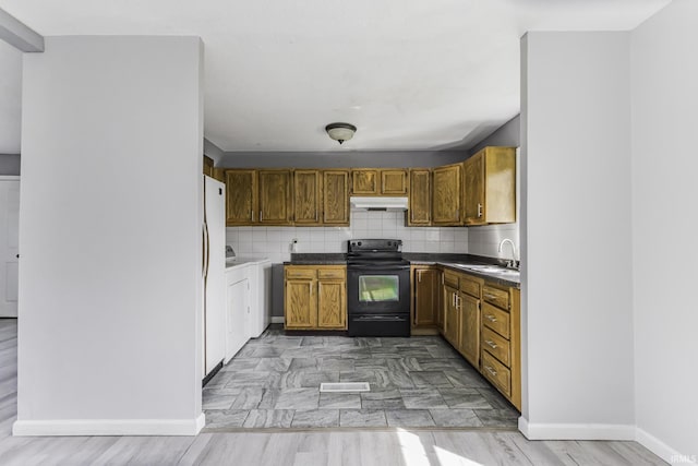 kitchen with decorative backsplash, dark countertops, under cabinet range hood, a sink, and black electric range
