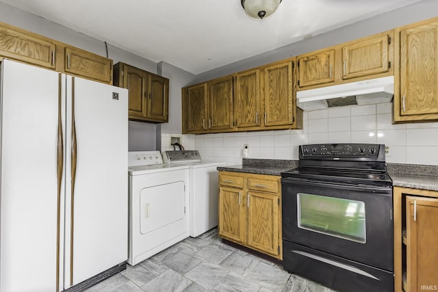 kitchen with freestanding refrigerator, tasteful backsplash, washing machine and clothes dryer, under cabinet range hood, and electric range