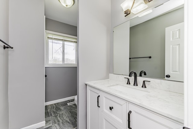 bathroom with baseboards, toilet, and vanity