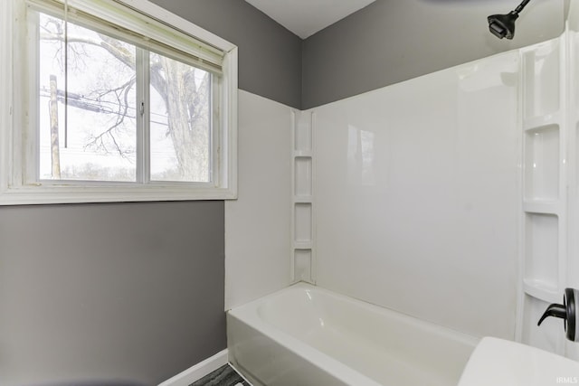 full bathroom with plenty of natural light, baseboards, and washtub / shower combination