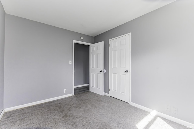 unfurnished bedroom with baseboards and carpet floors