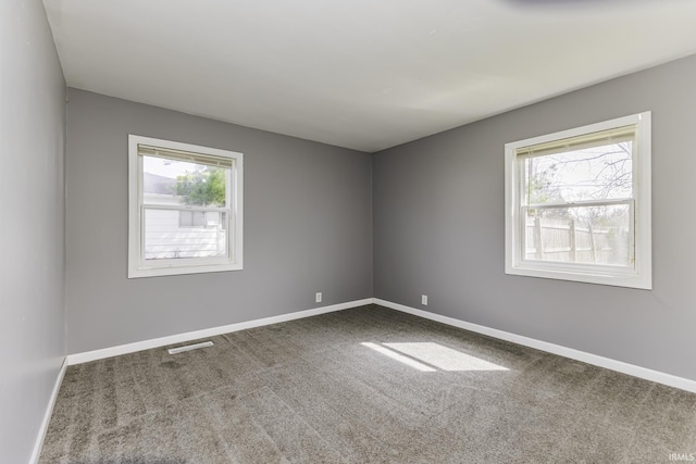 spare room with baseboards, carpet floors, and visible vents