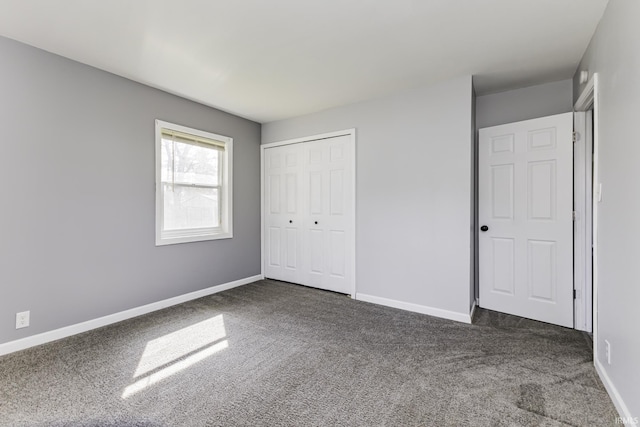 unfurnished bedroom featuring baseboards, a closet, and carpet