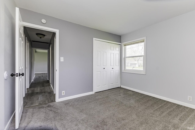 unfurnished bedroom with baseboards, a closet, and carpet