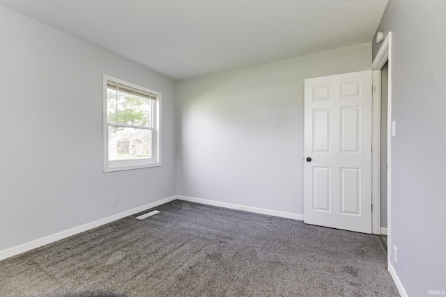 spare room with baseboards, visible vents, and carpet floors
