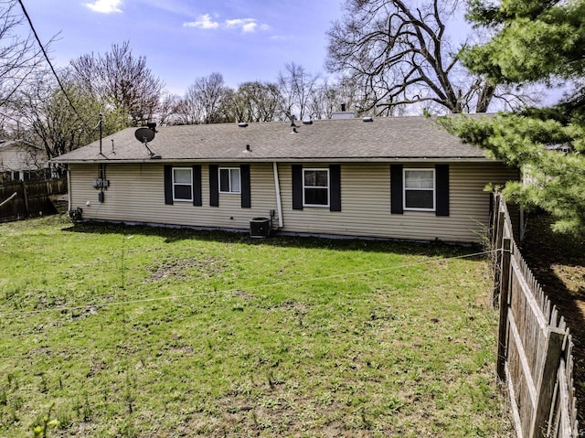 back of property featuring central air condition unit, a chimney, fence, and a yard