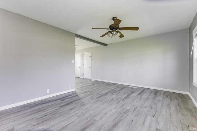 unfurnished room with baseboards, wood finished floors, and a ceiling fan