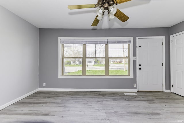 foyer with baseboards, ceiling fan, and wood finished floors