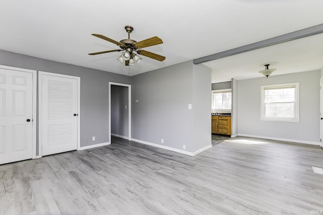 interior space with baseboards, light wood-type flooring, and a ceiling fan