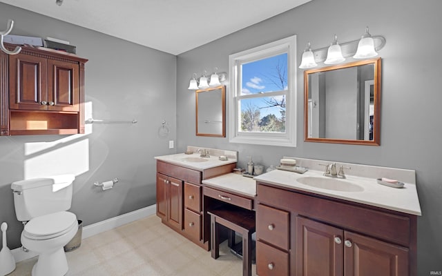 bathroom featuring toilet, a sink, tile patterned floors, and double vanity