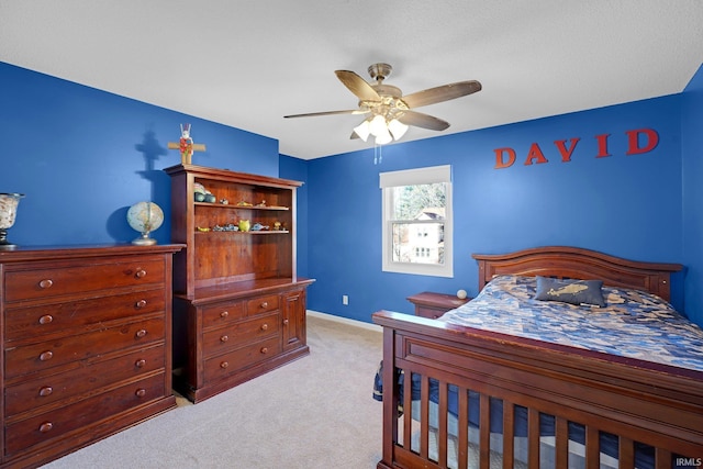 bedroom with a ceiling fan, baseboards, and light colored carpet