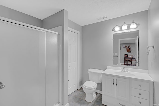 bathroom with vanity, toilet, a textured ceiling, a stall shower, and visible vents