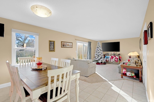dining space with light tile patterned floors, plenty of natural light, and light carpet