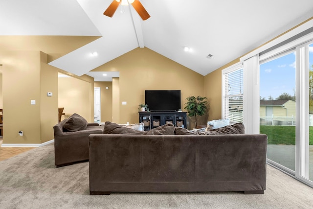 living room featuring light colored carpet, vaulted ceiling with beams, ceiling fan, and plenty of natural light