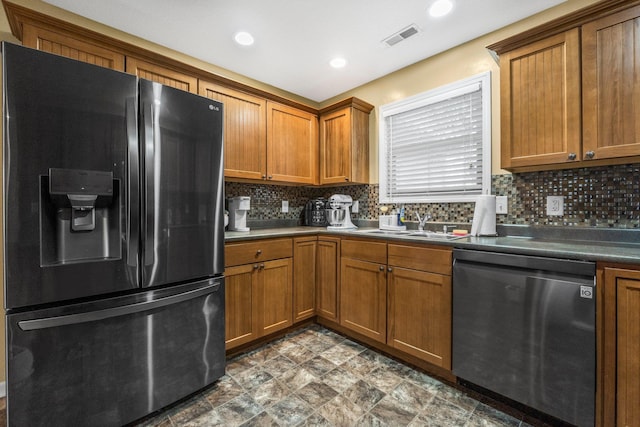 kitchen with visible vents, refrigerator with ice dispenser, dishwasher, brown cabinets, and tasteful backsplash