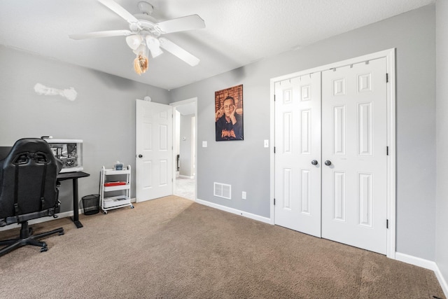 carpeted office featuring baseboards, ceiling fan, and visible vents