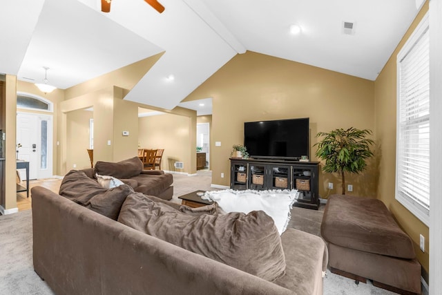 living area with lofted ceiling with beams, ceiling fan, baseboards, and light colored carpet