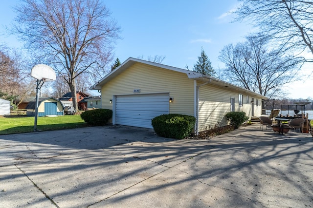 2680 S 390 W, Pleasant Lake, IN 46779 - view of home's exterior with an outdoor structure, fence, driveway, a garage, and a lawn