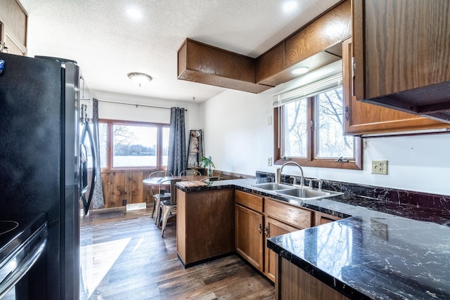 2680 S 390 W, Pleasant Lake, IN 46779 - kitchen with a textured ceiling, a peninsula, dark wood finished floors, a sink, and range with electric stovetop