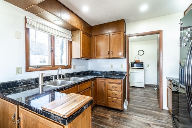 2680 S 390 W, Pleasant Lake, IN 46779 - kitchen featuring a sink, a peninsula, dark wood finished floors, brown cabinetry, and black appliances