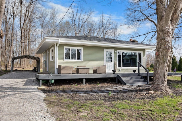 5255 E Bay Front Ct, Monticello, IN 47960 - back of property featuring gravel driveway, a detached carport, and a chimney