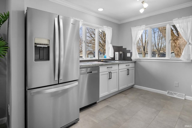 5255 E Bay Front Ct, Monticello, IN 47960 - kitchen with a wealth of natural light, appliances with stainless steel finishes, visible vents, white cabinets, and ornamental molding