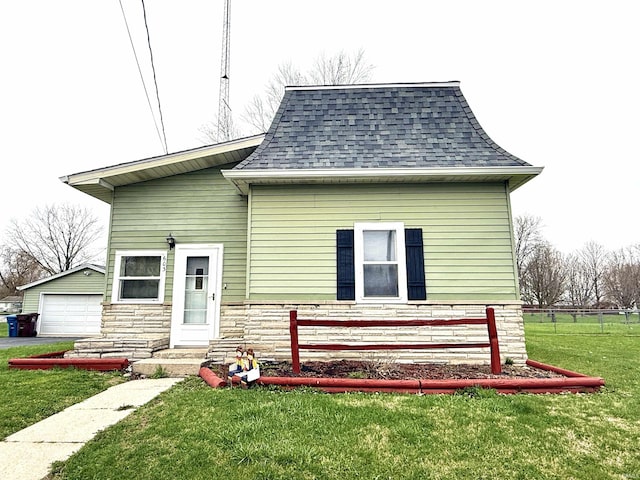 603 N Maple St, Converse, IN 46919 - rear view of property with a shingled roof, an outbuilding, stone siding, and a yard