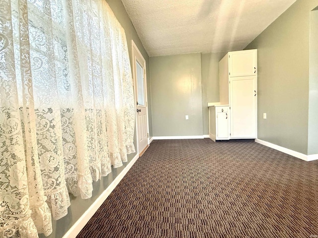 603 N Maple St, Converse, IN 46919 - hallway featuring baseboards, dark colored carpet, and a textured ceiling