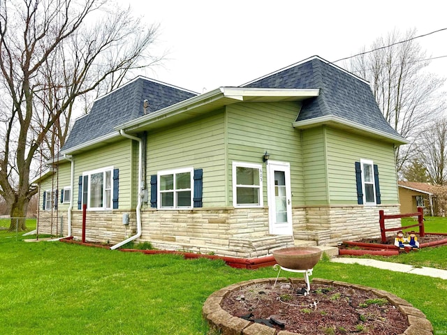603 N Maple St, Converse, IN 46919 - rear view of property featuring stone siding, a yard, mansard roof, and roof with shingles