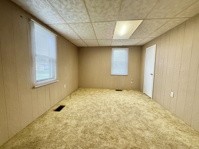603 N Maple St, Converse, IN 46919 - unfurnished bedroom featuring visible vents, wooden walls, multiple windows, and carpet
