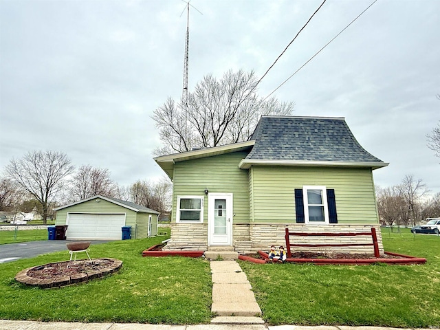 603 N Maple St, Converse, IN 46919 - view of front of home with a front yard, stone siding, an outbuilding, a shingled roof, and a garage