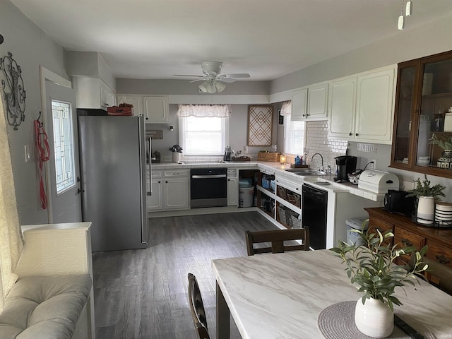 kitchen with a sink, ceiling fan, freestanding refrigerator, white cabinets, and wood finished floors
