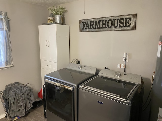laundry area featuring wood finished floors, washing machine and clothes dryer, and laundry area