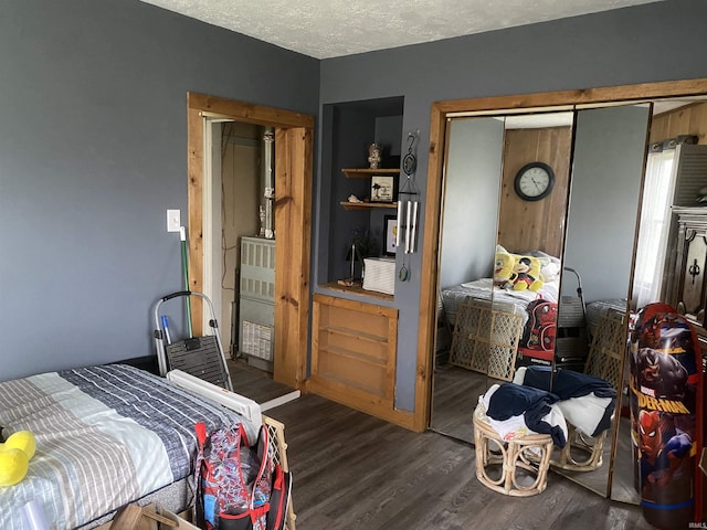 bedroom with a textured ceiling and wood finished floors