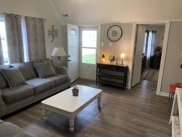 living area with baseboards, visible vents, wood finished floors, and vaulted ceiling