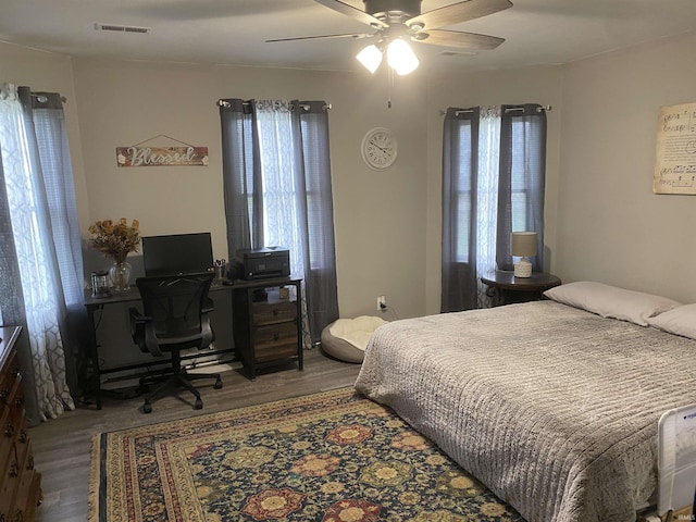 bedroom featuring visible vents, wood finished floors, and a ceiling fan