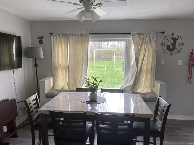 dining area featuring baseboards, wood finished floors, and ceiling fan