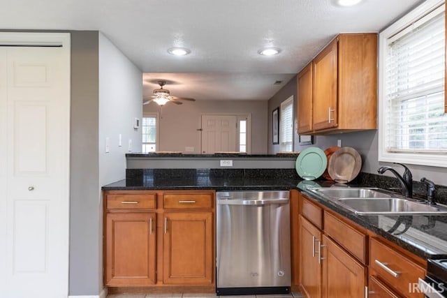 kitchen featuring brown cabinetry, dishwasher, a sink, and ceiling fan