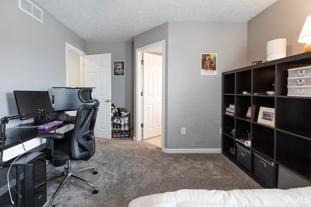 home office featuring a textured ceiling, baseboards, carpet, and visible vents