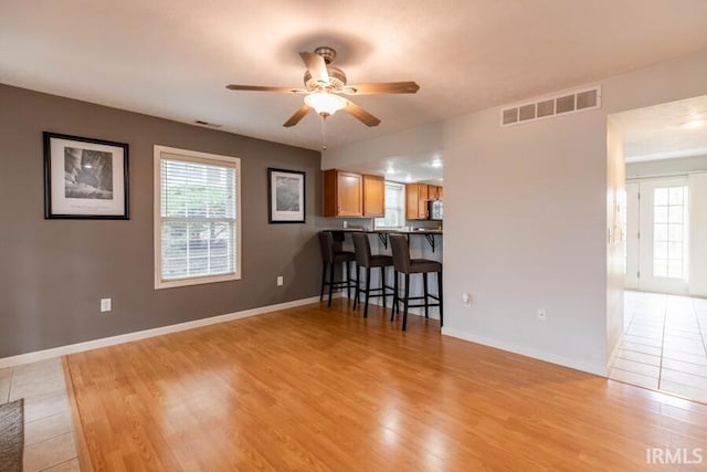 interior space with visible vents, a wealth of natural light, light wood-type flooring, and ceiling fan