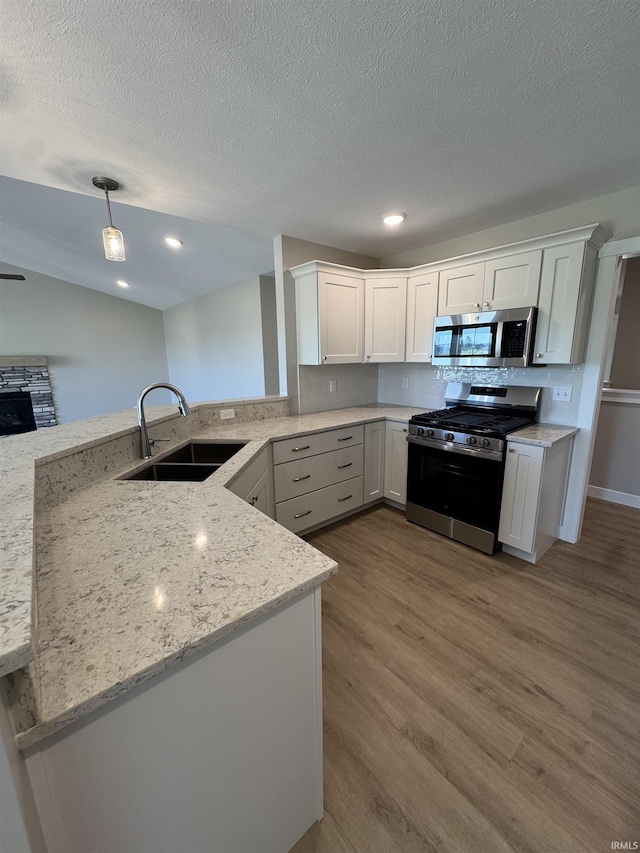 5115 Bankside Ct, Mishawaka, IN 46544 - kitchen with appliances with stainless steel finishes, a sink, wood finished floors, white cabinetry, and a textured ceiling