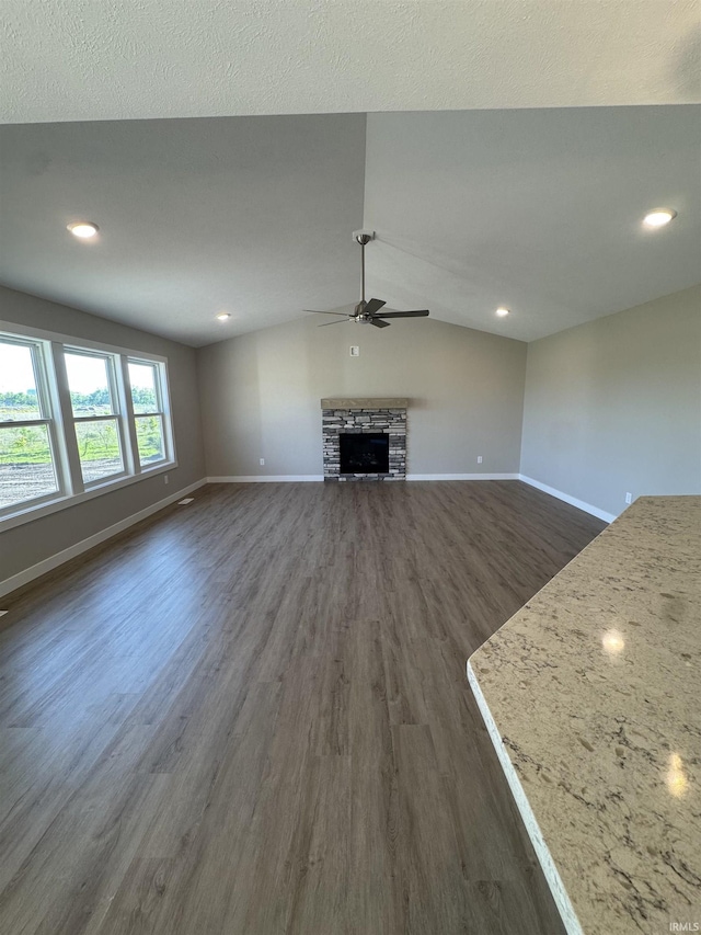 5115 Bankside Ct, Mishawaka, IN 46544 - unfurnished living room featuring dark wood-type flooring, baseboards, a ceiling fan, a fireplace, and vaulted ceiling