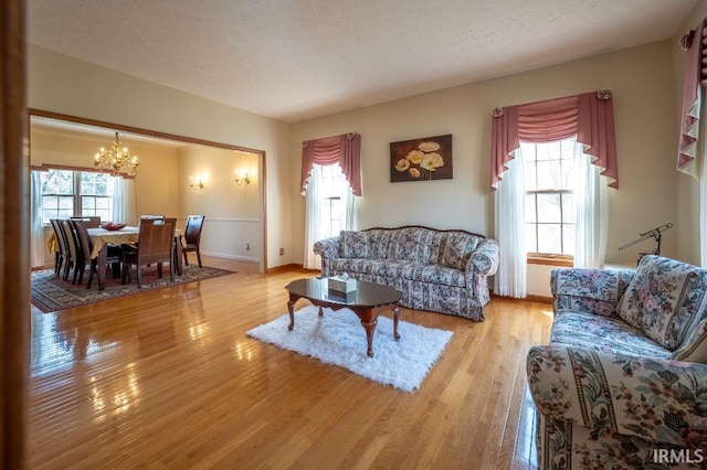 455 Lagrange St, West Lafayette, IN 47906 - living room featuring baseboards, a notable chandelier, wood finished floors, and a textured ceiling