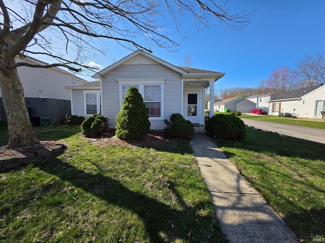 bungalow-style home with fence and a front yard