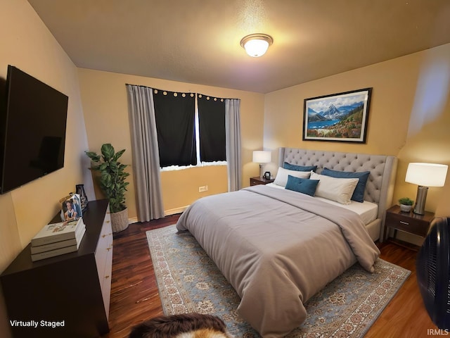 bedroom with wood finished floors and baseboards